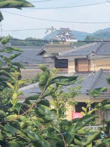 Blick auf die Dächer von Häusern und Bäumen in der Unterkunft GUEST HOUSE NAGORIYA in Hikone