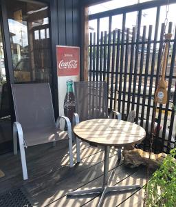 a table and a chair and a soda bottle on a patio at GUEST HOUSE NAGORIYA in Hikone
