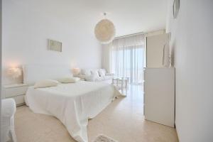 a white room with a bed and a refrigerator at CAELIA Residence ap 2 camere in Mamaia