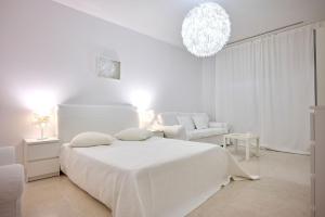 - une chambre blanche avec un lit blanc et une chaise dans l'établissement CAELIA Residence ap 2 camere, à Mamaia