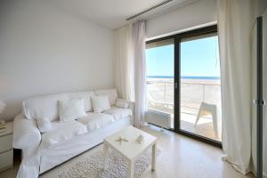 uma sala de estar com um sofá branco e vista para o oceano em CAELIA Residence ap 2 camere em Mamaia