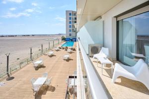 einen Balkon mit weißen Tischen und Stühlen sowie Strand in der Unterkunft CAELIA Residence ap 2 camere in Mamaia