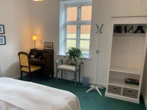 - une chambre avec un lit, un bureau et une fenêtre dans l'établissement Værelse ved Nykøbing F., à Nykøbing Falster