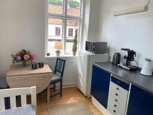 una cucina con bancone blu e tavolo di Værelse ved Nykøbing F. a Nykøbing Falster