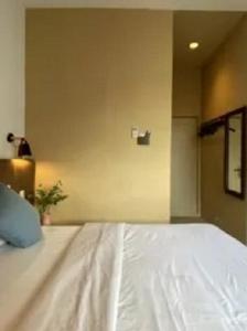 a white bed in a room with at Vosstel Guest House in Medan