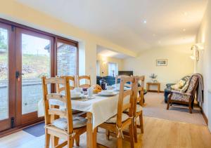 a dining room and living room with a table and chairs at Danycrug Barn in Brecon