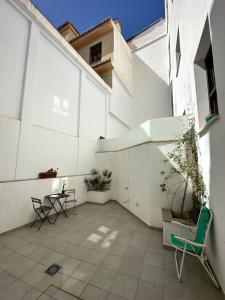 un patio con 2 sillas y una mesa en un edificio en Nest Flats Granada, en Granada