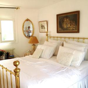 uma grande cama branca com almofadas brancas num quarto em Villla Ativoli em Vence