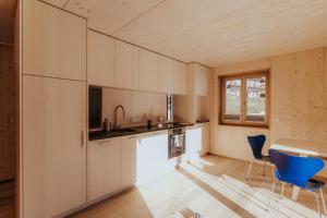 a kitchen with white cabinets and a table and chairs at Haus W in Schruns