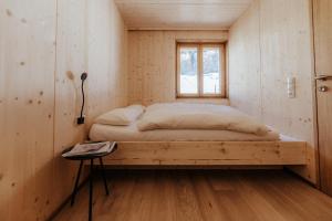 een bed in een kleine kamer met een raam bij Haus W in Schruns