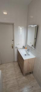 ein Bad mit einem Waschbecken und einem Spiegel in der Unterkunft Apartamento al lado del Museo DalÍ in Figueres
