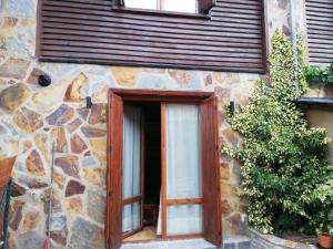 een deur op een stenen gebouw met een raam bij Pequeño adosado de montaña con terraza in Villanova