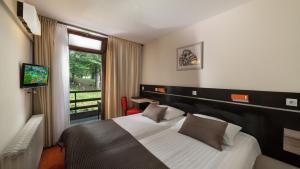 une chambre d'hôtel avec un lit et une télévision dans l'établissement Hotel Bellevue, aux lacs de Plitvice