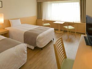 a hotel room with two beds and a table at Sapporo View Hotel Odori Park in Sapporo