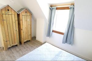 Habitación con armarios de madera y ventana. en Cottage 4 pers, jardin plein sud, vue sur la dune, en Le Touquet-Paris-Plage