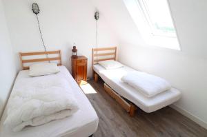 2 camas en una habitación pequeña con ventana en Cottage 4 pers, jardin plein sud, vue sur la dune, en Le Touquet-Paris-Plage