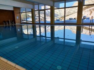 uma piscina com vista para uma montanha coberta de neve em Schwarzeck34 em Bachwinkl