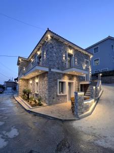 una casa de piedra con luces en la parte delantera en Zeus & Emmanuil Luxury Houses, en Mirina