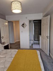 a room with a bed and a bathroom with a yellow rug at Modern two bedroom flat in North Stifford