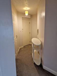 ein Bad mit einem Stuhl und einem Waschbecken in einem Zimmer in der Unterkunft Modern two bedroom flat in North Stifford