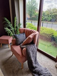 ein Wohnzimmer mit einem Stuhl und einem Fenster in der Unterkunft Modern two bedroom flat in North Stifford
