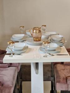 einen weißen Tisch mit Tellern und Weingläsern darauf in der Unterkunft Modern two bedroom flat in North Stifford