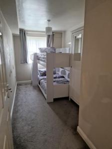 a small room with two bunk beds with a window at Modern two bedroom flat in North Stifford