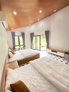 a large bedroom with two beds and windows at Green Hill Ba Vi Venuestay in Ba Vì