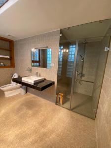 een badkamer met een douche, een wastafel en een toilet bij Green Hill Ba Vi Venuestay in Ba Vì