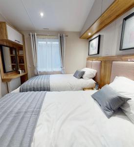 a bedroom with two beds and a window at Presthaven Resort Haven Luxury 2023 Caravan in Prestatyn