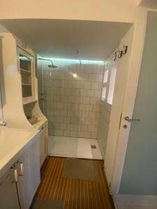 La salle de bains blanche est pourvue d'une douche et d'un lavabo. dans l'établissement I Bravi, à Malgrate
