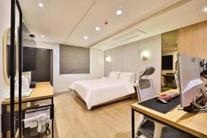 een hotelkamer met een bed en een bureau met een computer bij Hotel Rubato Ulsan Jung-gu Haksung in Ulsan