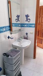 ein Badezimmer mit einem Waschbecken, einem WC und einem Spiegel in der Unterkunft Playaelporis in Poris de Abona