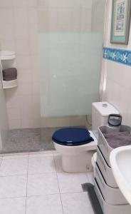 ein Badezimmer mit einem WC und einem blauen Sitz in der Unterkunft Playaelporis in Poris de Abona