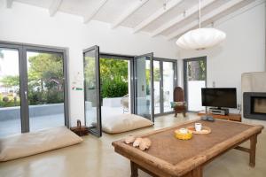 a living room with a table and a tv at Beach Villa Next To The Waves! in Istiaía