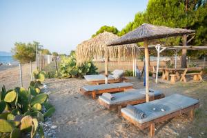 - un groupe de chaises longues et de parasols sur une plage dans l'établissement Beach Villa Next To The Waves!, à Istiaía