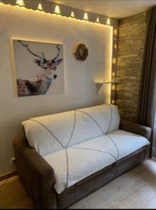 - un canapé dans une chambre avec des lumières sur le mur dans l'établissement Studio la Foux, à Allos