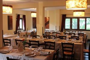 uma sala de jantar com mesas longas e cadeiras em Rifugio Fasanelli em Rotonda