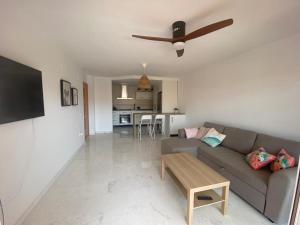 een woonkamer met een bank en een plafondventilator bij Horia Seaside in La Herradura