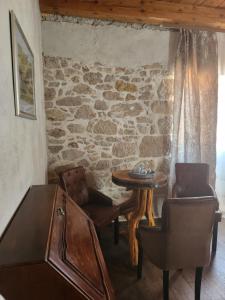 Pokój ze stołem i krzesłami oraz kamienną ścianą w obiekcie Boutique Vila Marijini Dvori w mieście Tribunj