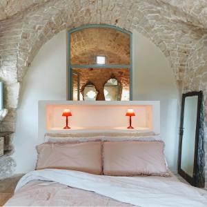 um quarto com uma cama com 2 candeeiros por cima em Masseria LoJazzo em Ceglie Messapica