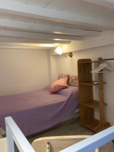 1 dormitorio con 2 camas con sábanas moradas y escalera en Pensione Della Nonna, en Mykonos ciudad