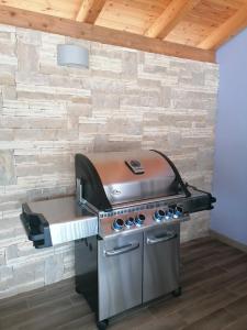 a grill in a room with a brick wall at House with pool in Mali Lošinj