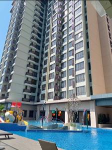 a large apartment building with a swimming pool in front of it at Bali Residence Melaka by Naufal in Melaka