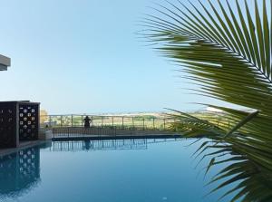 uitzicht op een zwembad met een palmboom bij Bali Residence Melaka by Naufal in Melaka