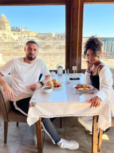 Ein Mann und eine Frau sitzen an einem Tisch mit Essen in der Unterkunft Gedik Cave Hotel in Goreme