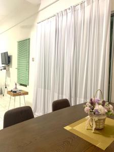 a room with a table with chairs and a white curtain at Adel Homestay in Papar