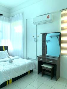 a bedroom with a bed and a desk with a tv at Adel Homestay in Papar