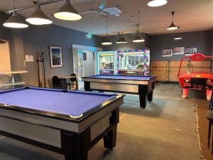 a billiard room with two pool tables and a arcade at Jurien Bay Hotel Motel in Jurien Bay