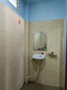 uma casa de banho com um lavatório e um espelho em Hotel Blue Coral Rameswaram em Rameswaram